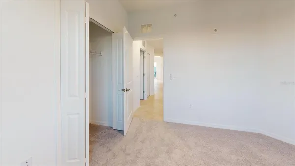 an empty room with a window and ceiling fan