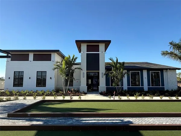 a view of a house with a yard and lawn chairs