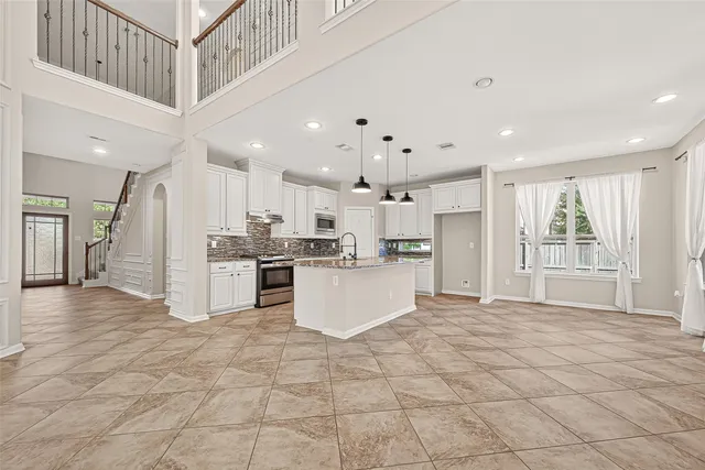 a kitchen with kitchen island granite countertop a sink cabinets and stainless steel appliances