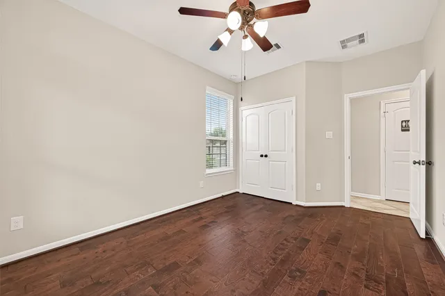 an empty room with a window and a fan