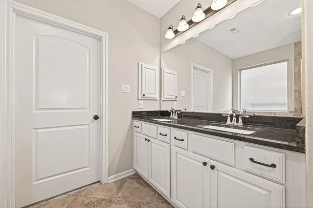 a bathroom with a granite countertop sink and a mirror