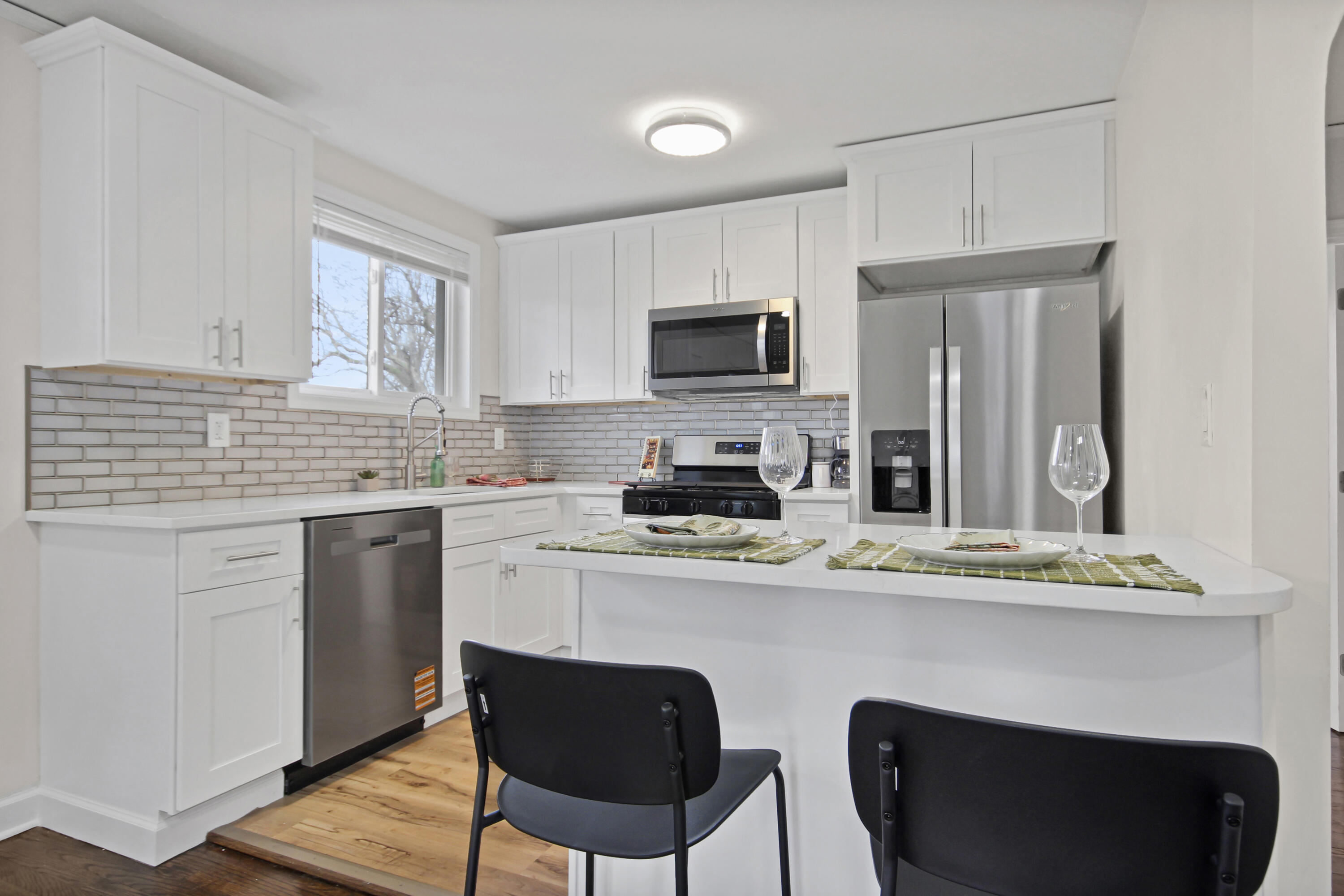405 Institute Street Valparaiso, IN 46383 - Photo 3 of 17 a kitchen with stainless steel appliances granite countertop a stove a sink dishwasher a refrigerator white cabinets and wooden floor