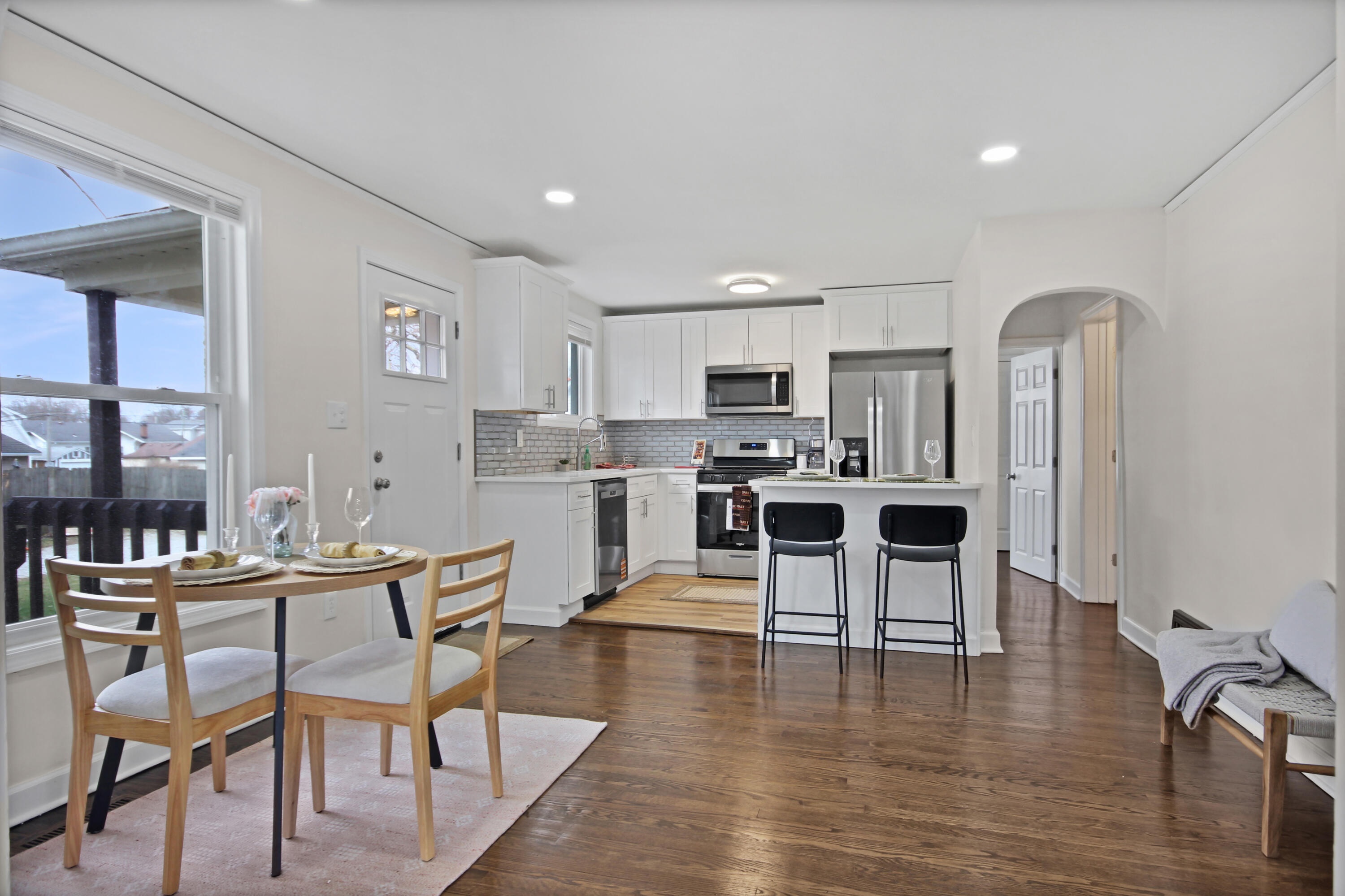 405 Institute Street Valparaiso, IN 46383 - Photo 4 of 17 a kitchen with stainless steel appliances kitchen island granite countertop a dining table chairs stove and white cabinets