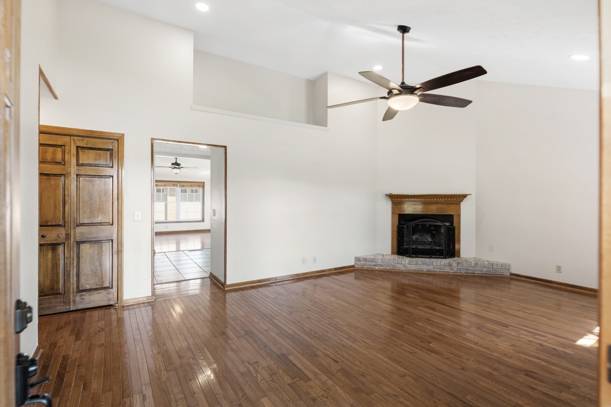 526 Calista Road White House, TN 37188 - Photo 3 of 29 an empty room with wooden floor a ceiling fan and fireplace