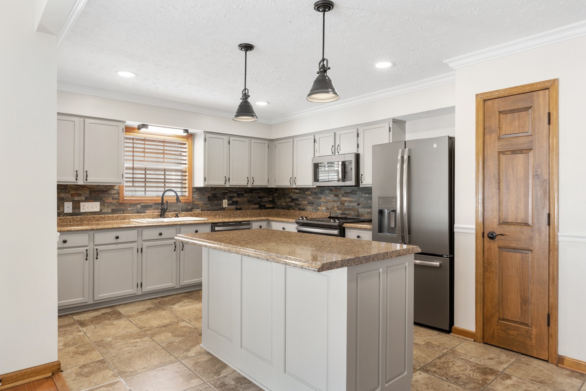 526 Calista Road White House, TN 37188 - Photo 7 of 29 a kitchen with stainless steel appliances granite countertop a refrigerator a sink dishwasher a stove and white cabinets with wooden floor