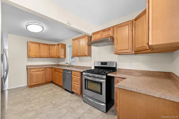 a kitchen with granite countertop a stove top oven sink and cabinets
