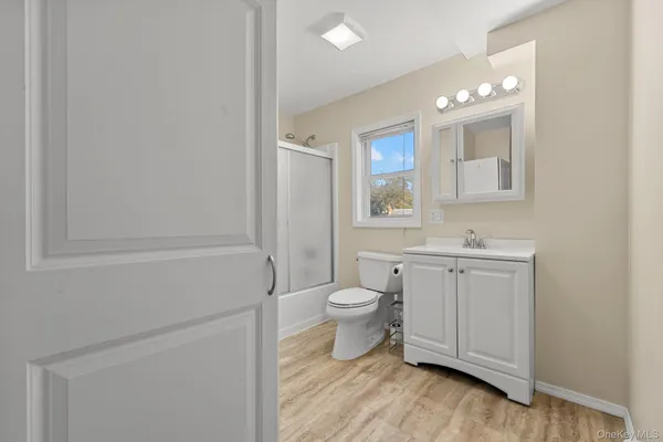 a bathroom with a toilet a sink a tub and mirror