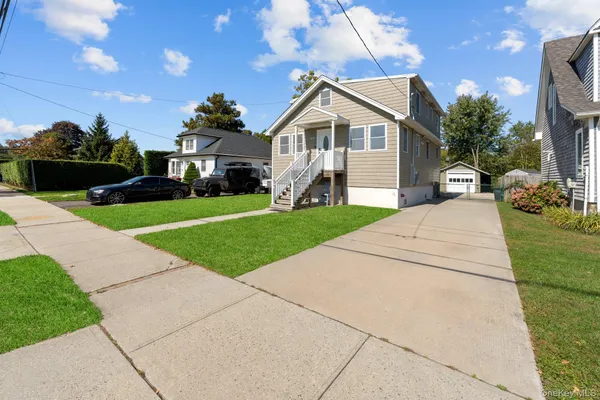 a front view of a house with a yard and potted plants