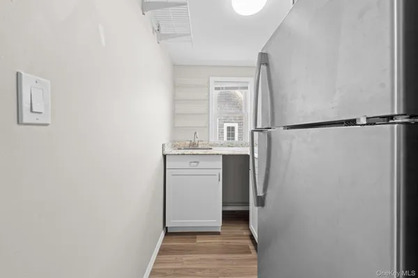 a room with a refrigerator and a sink