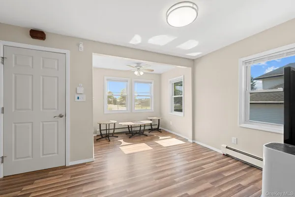 a view of a livingroom with wooden floor and a window