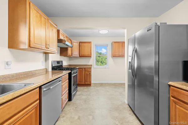 a kitchen with stainless steel appliances granite countertop a refrigerator a sink and a stove