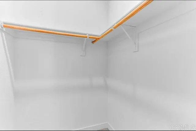 a view of an empty room with closet and a window