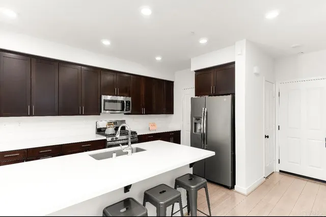 a kitchen with stainless steel appliances a refrigerator sink and microwave