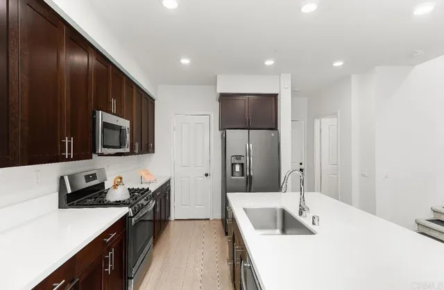 a kitchen with stainless steel appliances a sink stove and refrigerator
