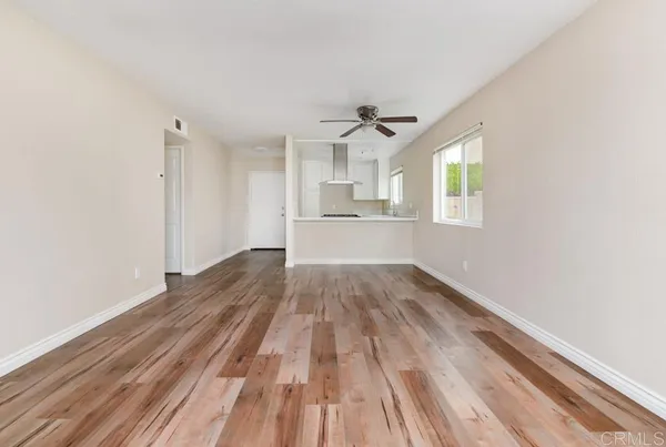 a view of empty room with wooden floor and window