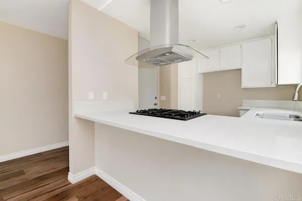 a kitchen with a refrigerator a ceiling fan and wooden floor