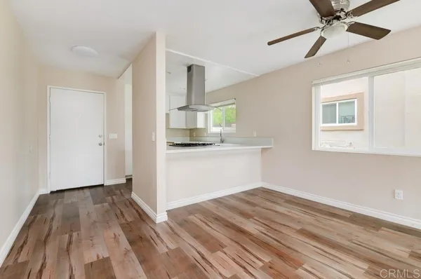 a view of a kitchen with wooden floor a sink and windows