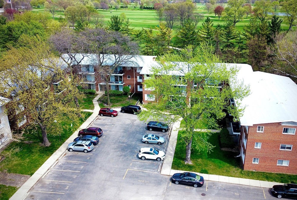 an aerial view of a house with a yard and a car park side of the road