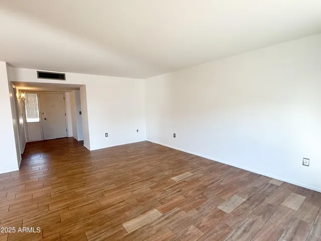 a view of empty room with wooden floor and cabinet