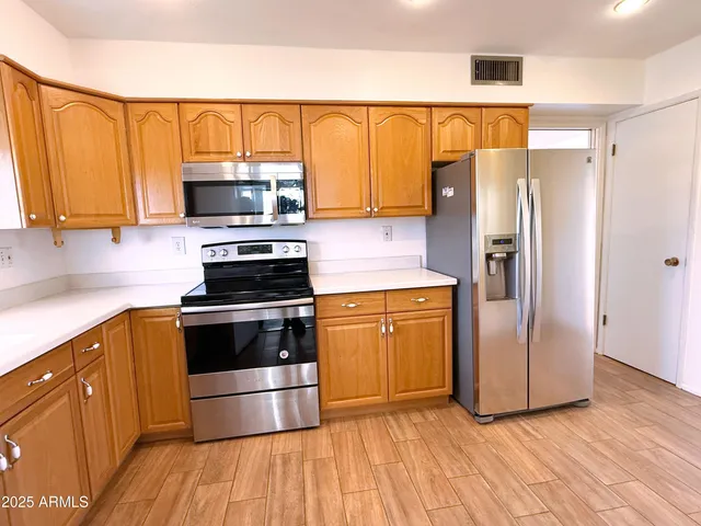 a kitchen with granite countertop a refrigerator stove and microwave