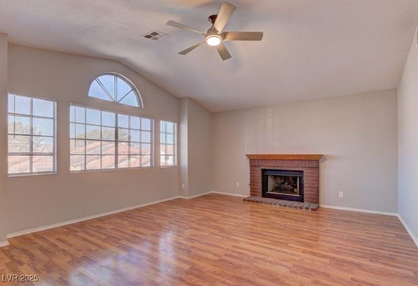 356 Amalfi Street Henderson, NV 89074 - Photo 10 of 15 Unfurnished living room with lofted ceiling, ceiling fan, light wood-style floors, and a fireplace