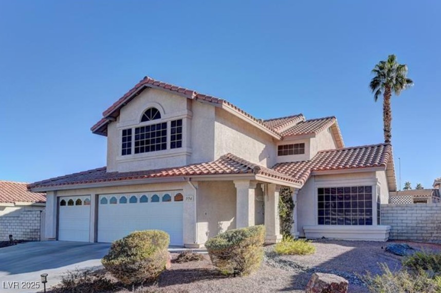 356 Amalfi Street Henderson, NV 89074 - Photo 2 of 15 Mediterranean / spanish house featuring stucco siding, an attached garage, a tile roof, and driveway