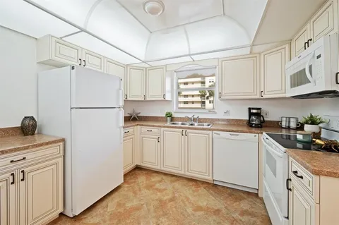 a kitchen with stainless steel appliances white cabinets and a stove top oven