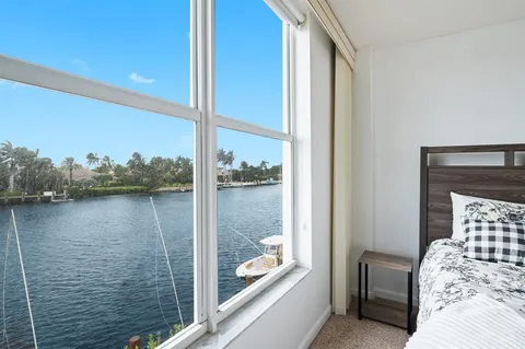 a bedroom with a bed and a large window