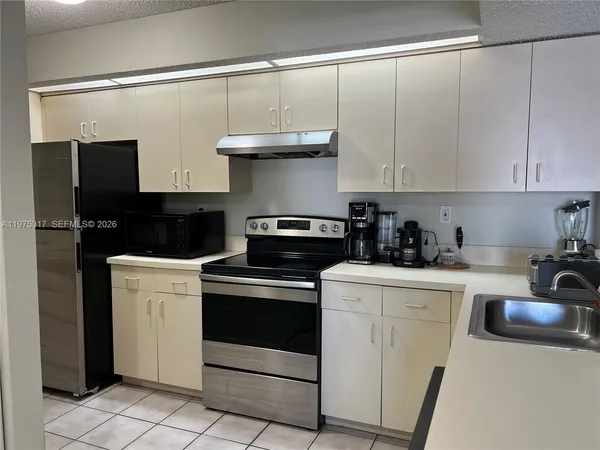 a kitchen with granite countertop white cabinets and black appliances