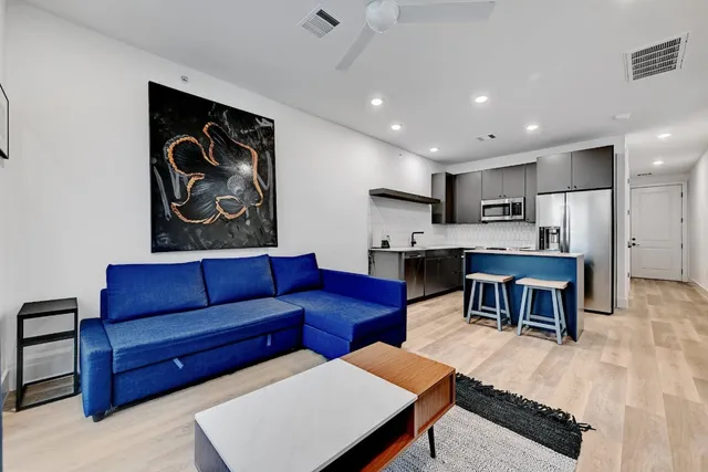 a living room with furniture kitchen view and a fireplace