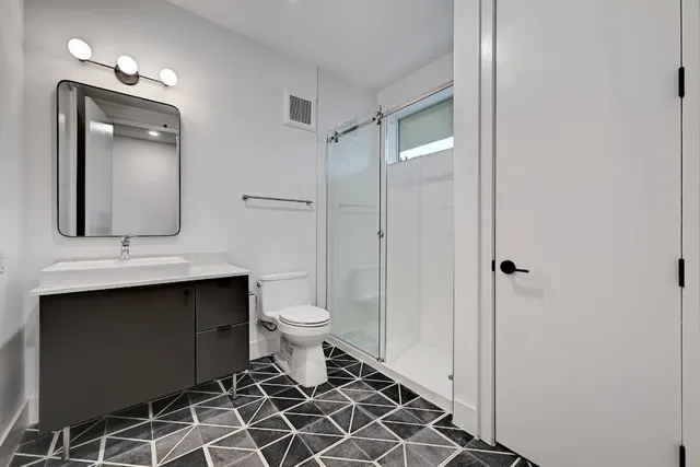 a bathroom with a toilet sink and mirror