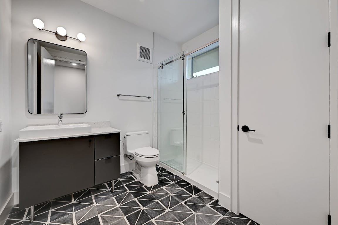 2709 East 5th Street, Unit 1303 Austin, TX 78702 - Photo 11 of 18 a bathroom with a toilet sink and mirror