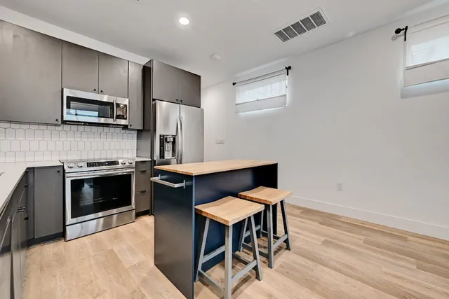 a kitchen with stainless steel appliances a stove a sink refrigerator and a microwave