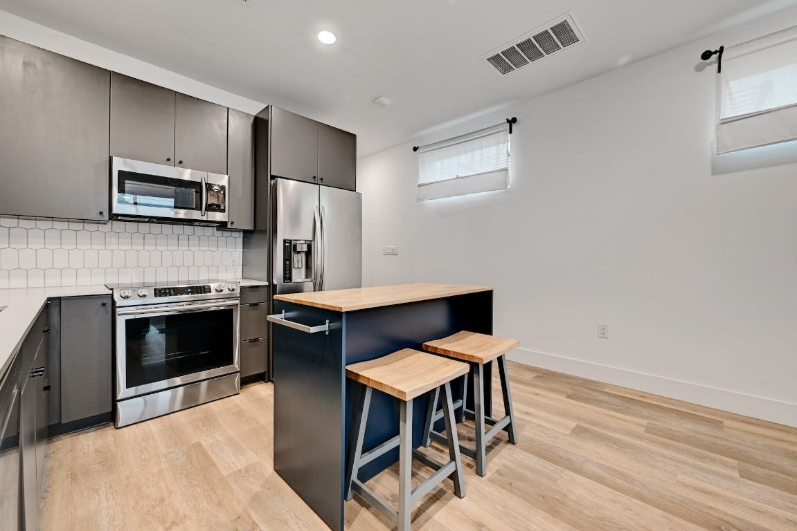 2709 East 5th Street, Unit 1303 Austin, TX 78702 - Photo 5 of 18 a kitchen with stainless steel appliances a stove a sink refrigerator and a microwave