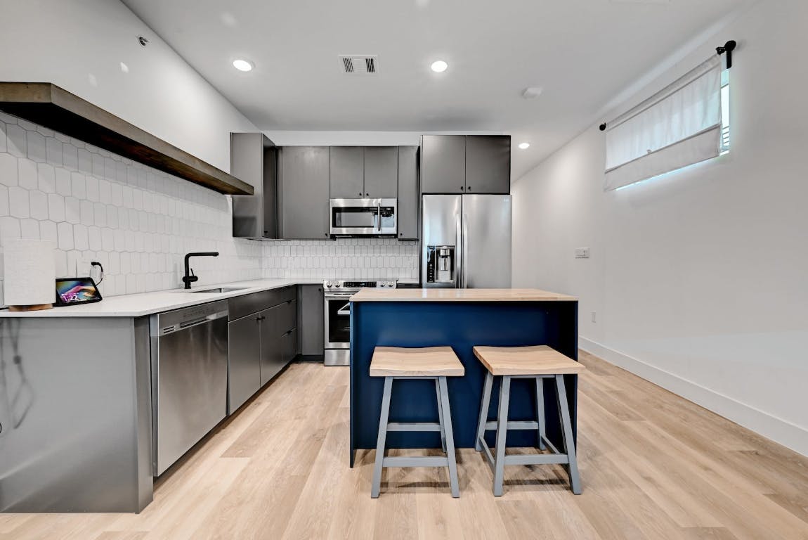 2709 East 5th Street, Unit 1303 Austin, TX 78702 - Photo 6 of 18 a kitchen with kitchen island stainless steel appliances cabinets a sink and a counter top space