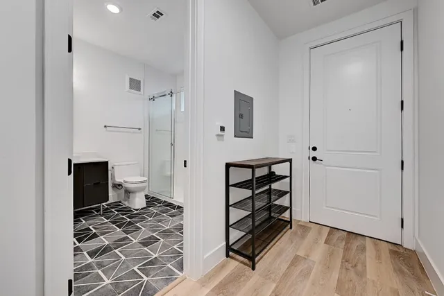 a view of a bedroom with wooden floor and bathroom