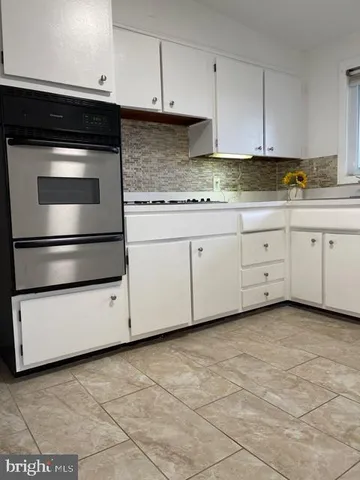 a kitchen with granite countertop white cabinets and stainless steel appliances
