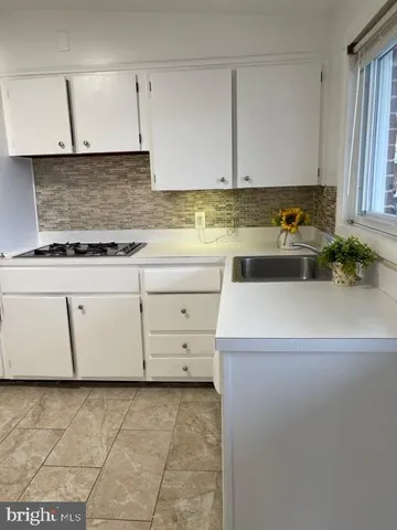 a view of a kitchen with cabinets washer and dryer