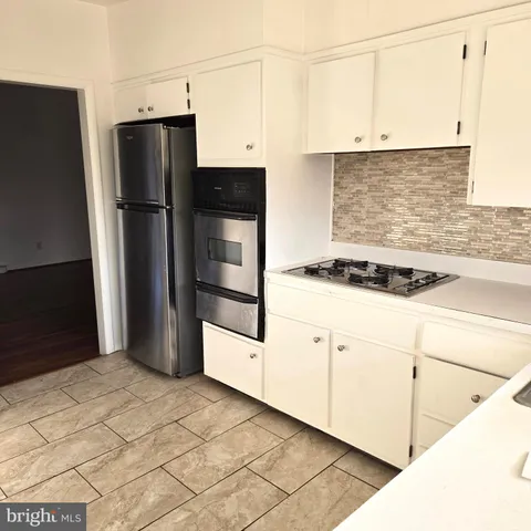 a kitchen with a refrigerator and white cabinets