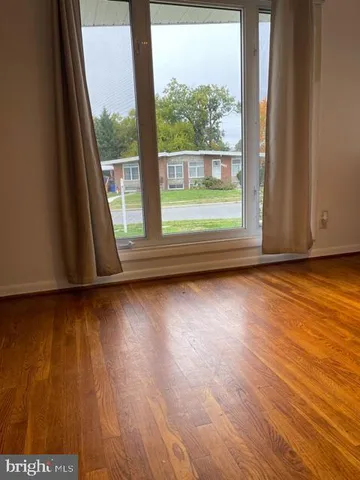 an empty room with wooden floor and door
