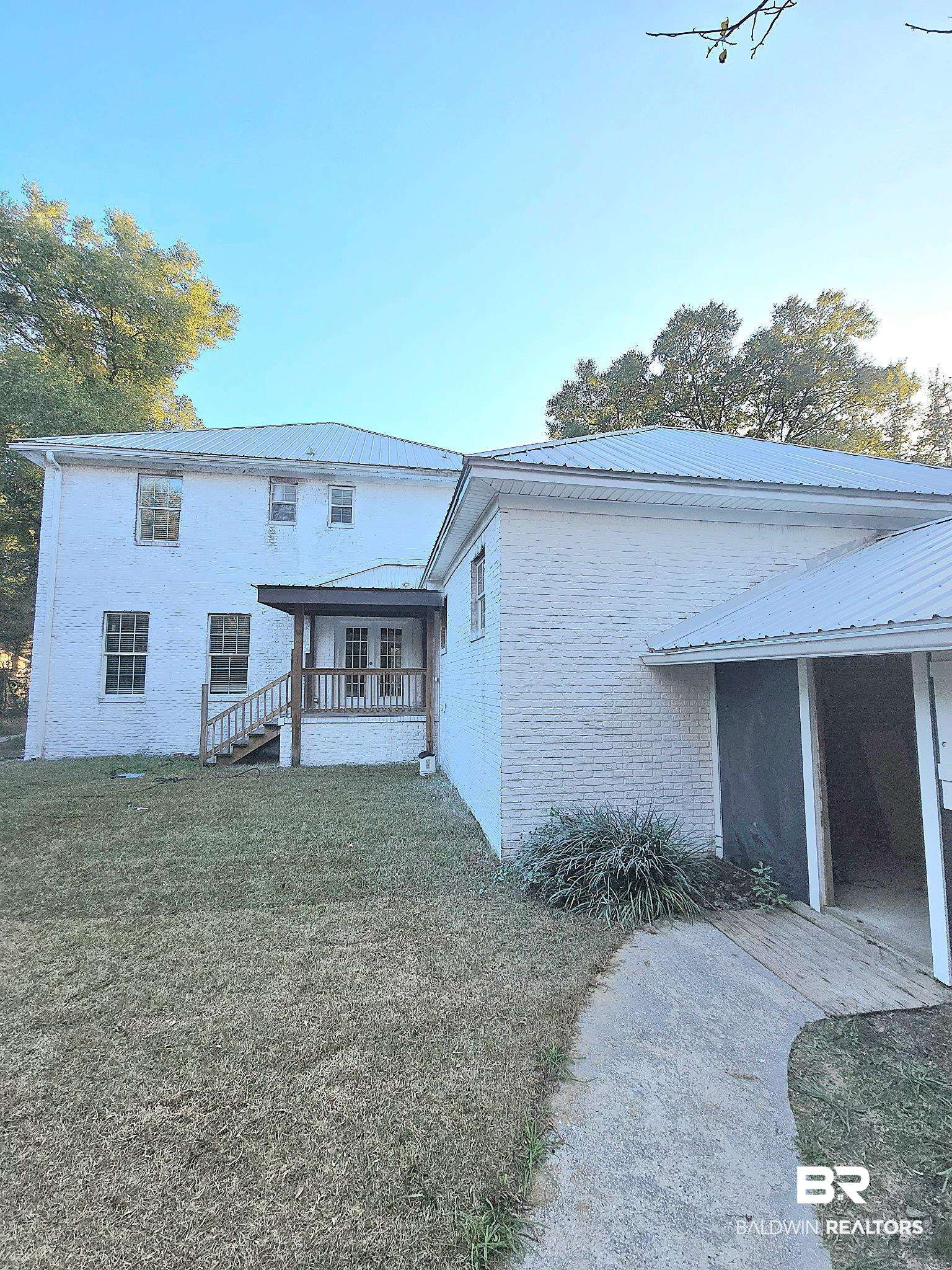 11835 Island Drive Foley, AL 36535 - Photo 45 of 53 Back of property with a metal roof, a yard, brick siding, and stairway