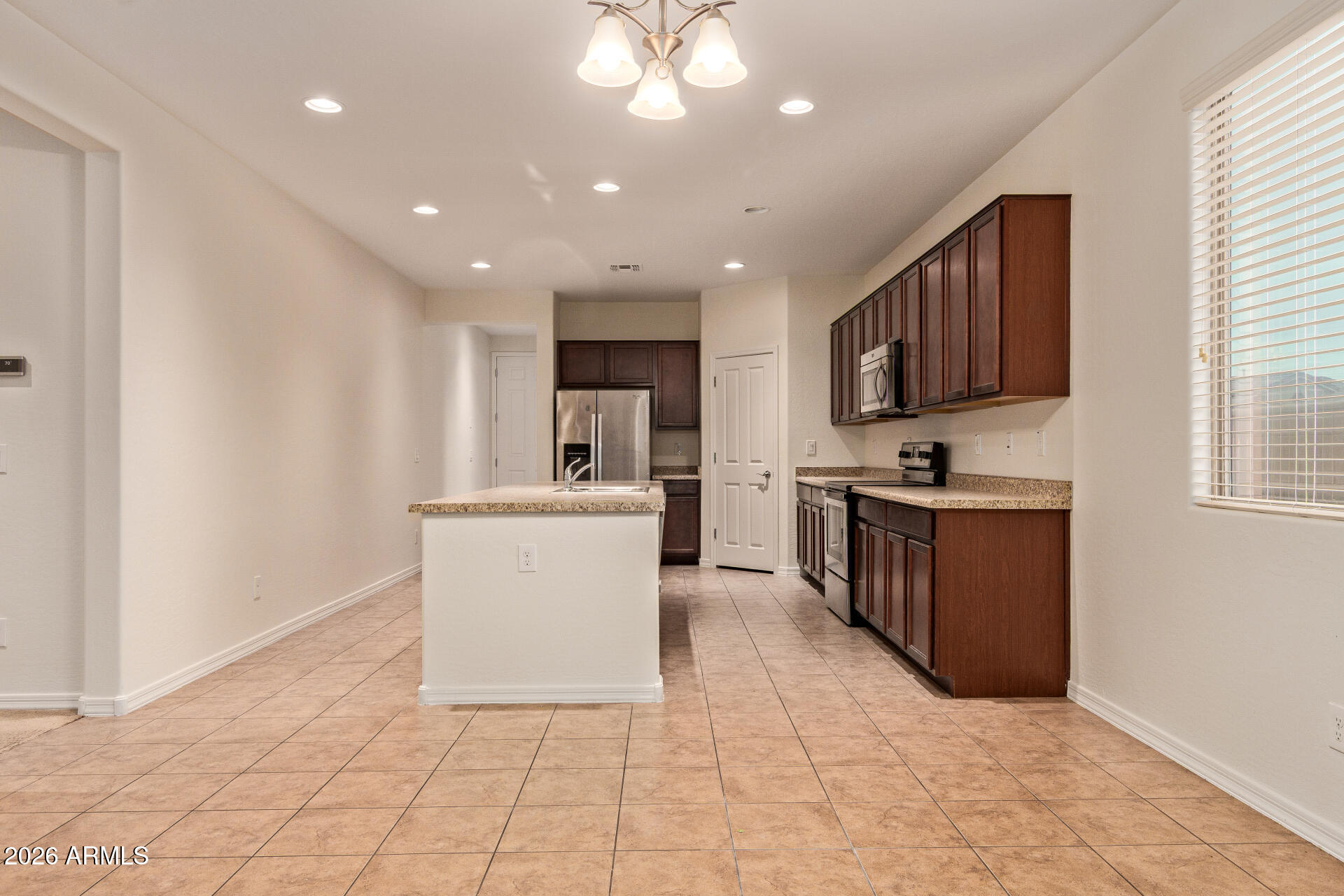 41334 West Rio Bravo Drive Maricopa, AZ 85138 - Photo 14 of 43 a room with stainless steel appliances kitchen island granite countertop a refrigerator and a sink