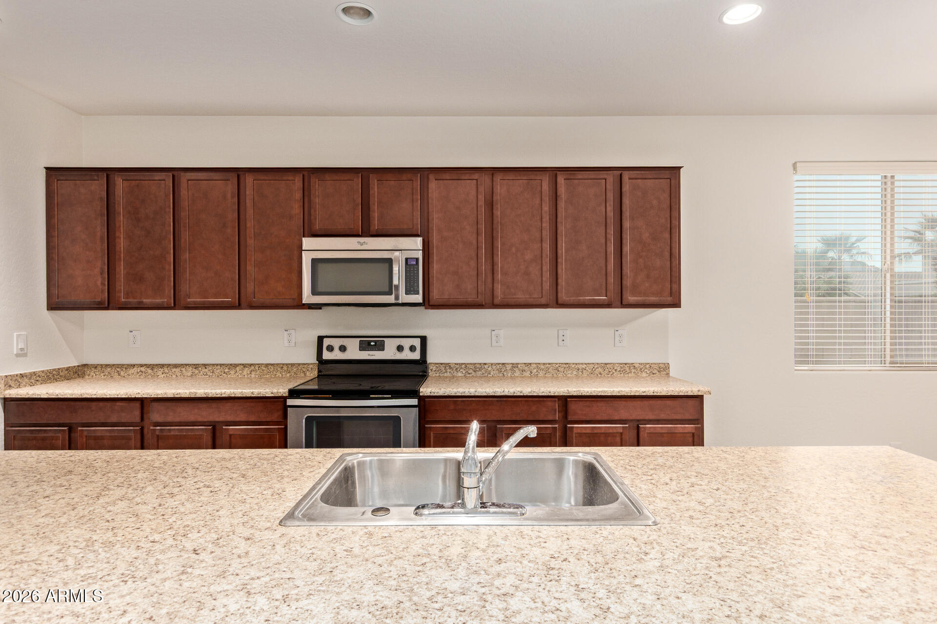 41334 West Rio Bravo Drive Maricopa, AZ 85138 - Photo 15 of 43 a kitchen with stainless steel appliances granite countertop a sink and a microwave
