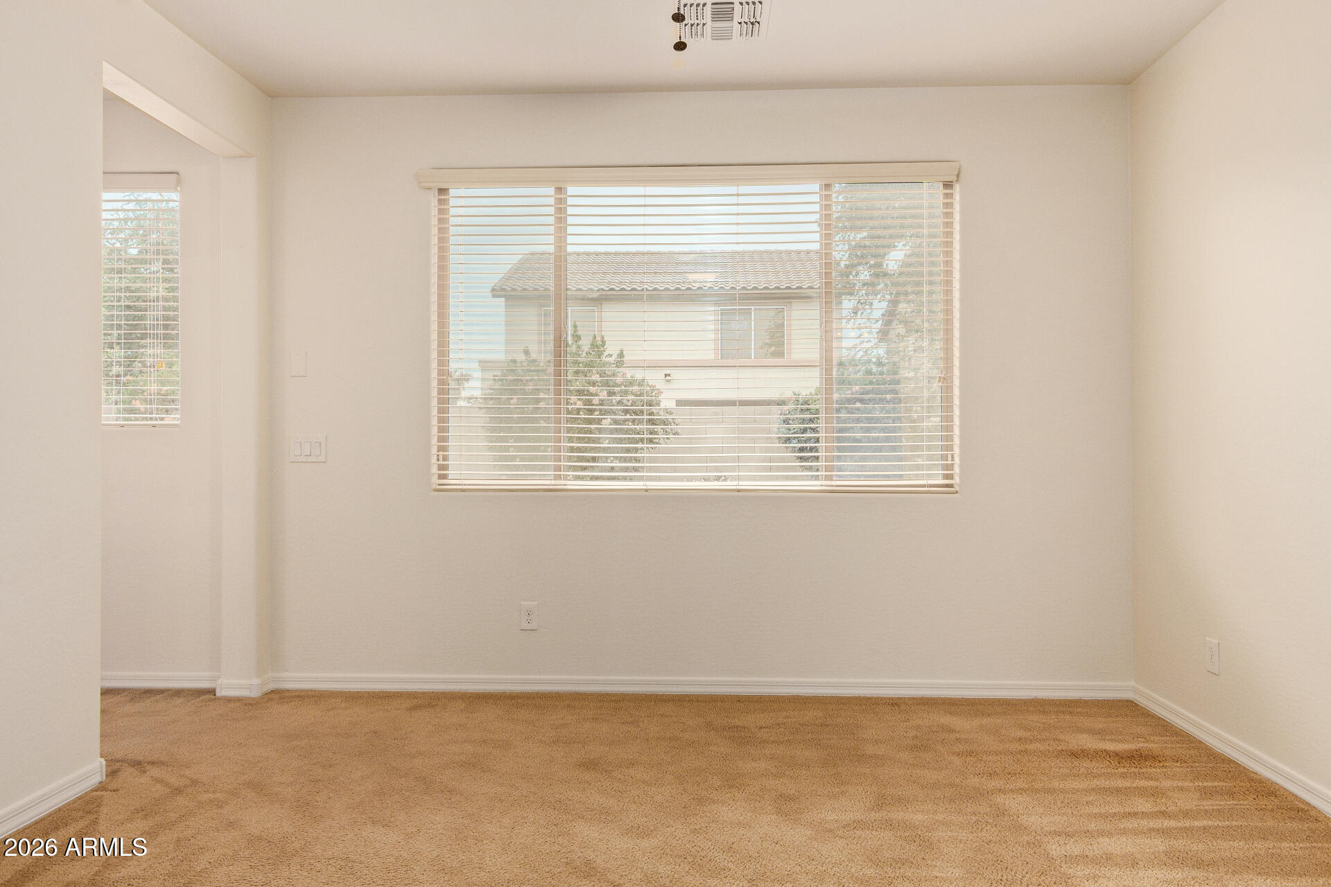 41334 West Rio Bravo Drive Maricopa, AZ 85138 - Photo 23 of 43 a view of an empty room with wooden floor and a window