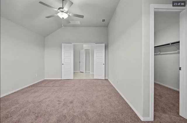 a view of an empty room with a ceiling fan
