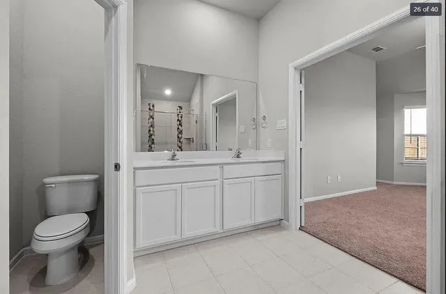 a spacious bathroom with a toilet sink and mirror