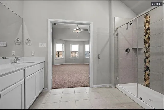 a bathroom with a granite countertop sink a mirror and a shower