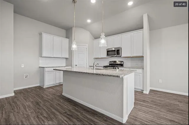 a kitchen with kitchen island a sink and a stove top oven
