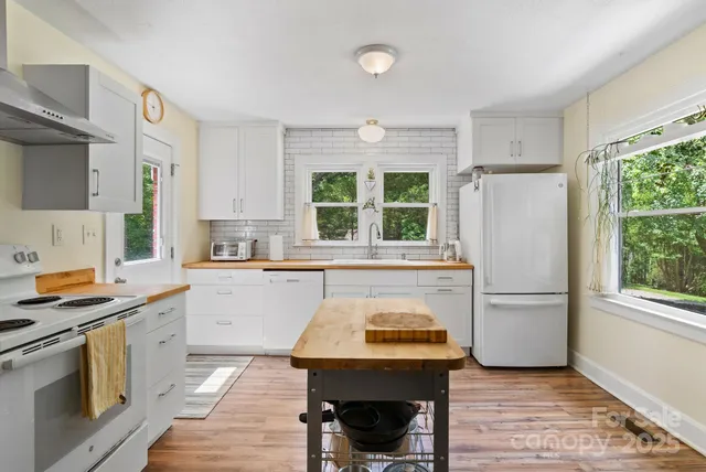 a kitchen with a refrigerator a stove a sink and a window