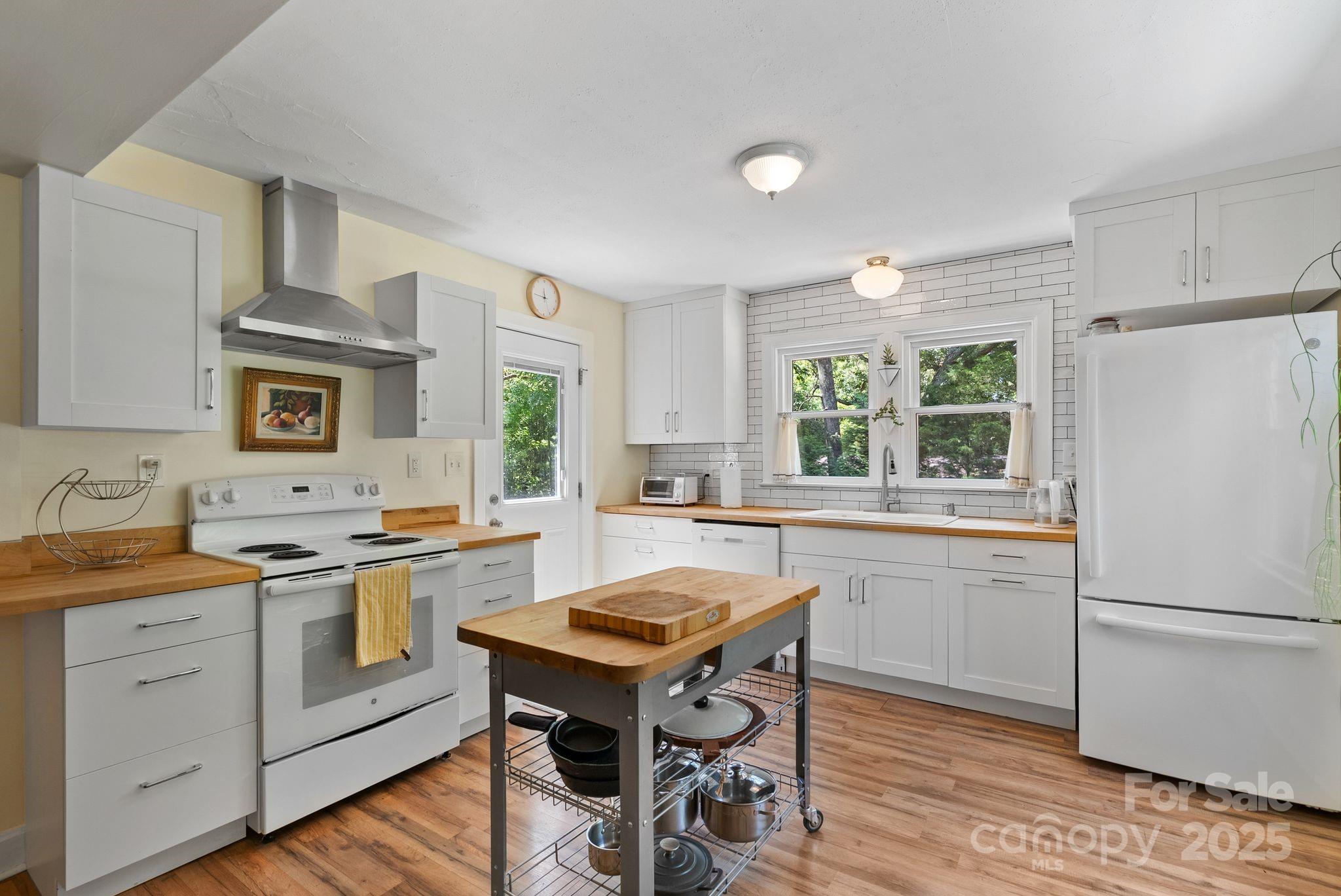 1215 Upper Brush Creek Road Fairview, NC 28730 - Photo 15 of 41 a kitchen with a stove a sink and a refrigerator